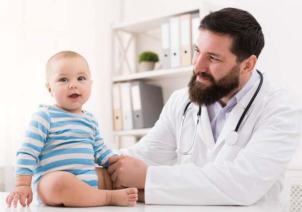 Очаровательный ребенок сидит с врачом в клинике
 - Фото, изображение