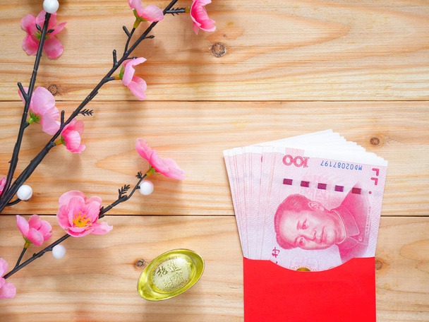 Pilha de dinheiro yuan chinês em envelope vermelho ou pacote vermelho em fundo de madeira com espaço de cópia. Conceito de ano novo chinês
. - Foto, Imagem