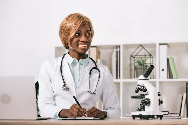 kaunis afrikkalainen amerikkalainen tiedemies istuu stetoskooppi
 - Valokuva, kuva