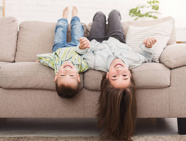 Go crazy together. Relaxing upside down on sofa - Fotografie, Obrázek