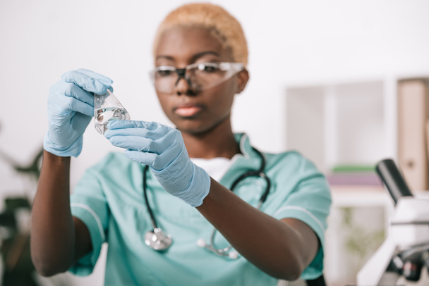 attrayant scientifique afro-américain tenant fiole de laboratoire en laboratoire
 - Photo, image