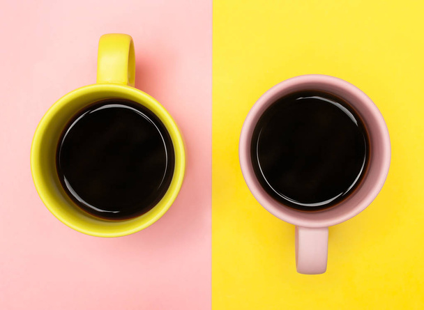 Plochá laický pohled shora dvěma šálky na kávu s růžová a žlutá. - Fotografie, Obrázek