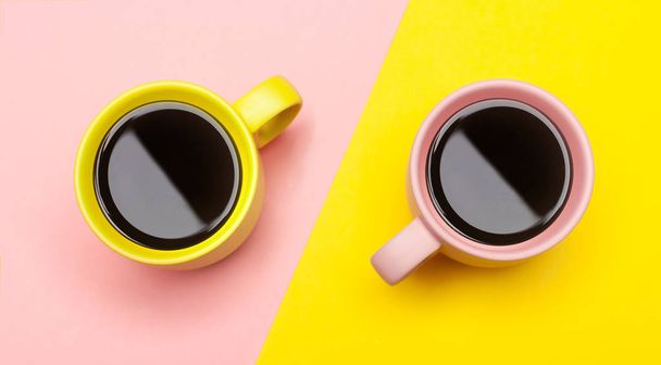 Vista superior plana de dos tazas de café con rosa y amarillo
. - Foto, Imagen