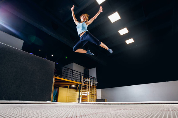 Jeune femme sportif fitness saut sur trampoline club
 - Photo, image