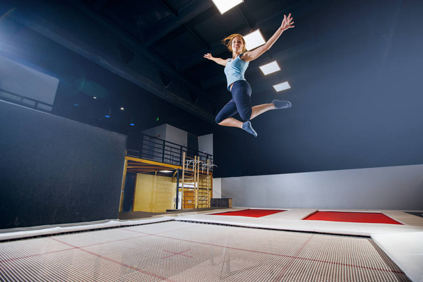 Jeune femme sportif fitness saut sur trampoline club
 - Photo, image