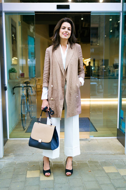 Portrait of stylish young beautiful businesswoman posing in the street outside the coffee shop. - Foto, Imagen