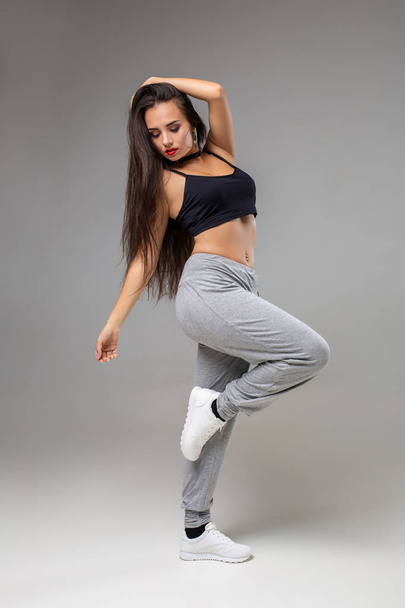 Bailarina de estilo moderno posando sobre fondo de estudio. Hip hop, jazz funk, dancehall
 - Foto, imagen