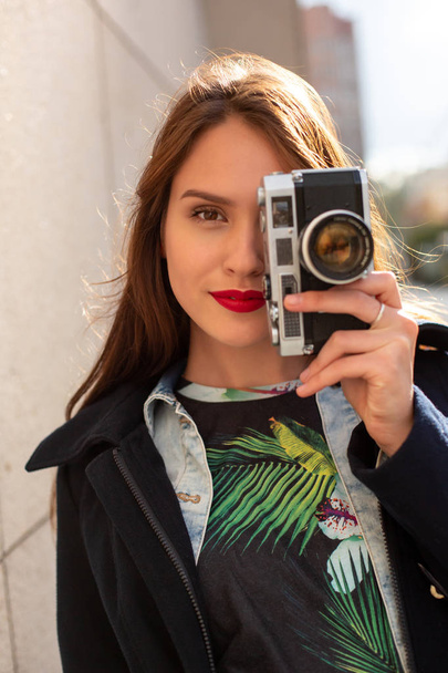 Onnellinen hipster tyttö tekee valokuvan retro kamera kaupungin kadulla
 - Valokuva, kuva