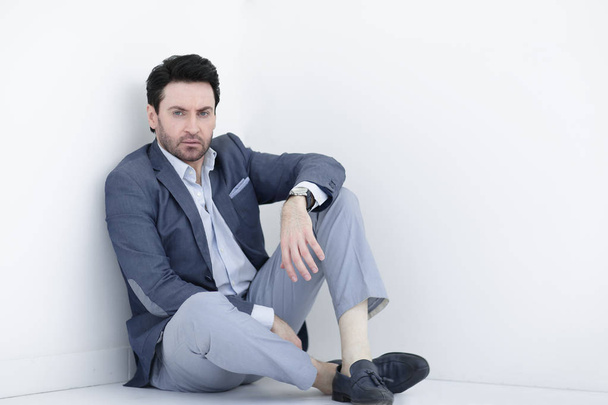 frustrated businessman sitting near the white wall - Fotografie, Obrázek