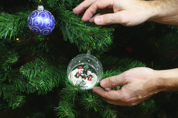 parents dress up a Christmas tree or a New Year tree for children - Φωτογραφία, εικόνα