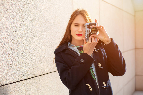 Porträt einer hübschen jungen Touristin beim Fotografieren mit einer alten Retro-Kamera - Foto, Bild