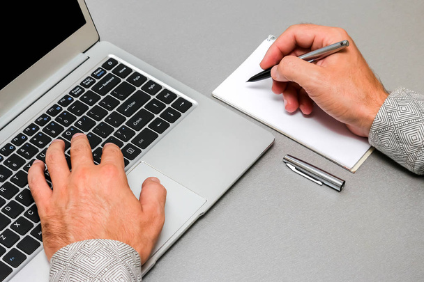 Крупный план руки бизнесмена, работающего с ноутбуком
. - Фото, изображение