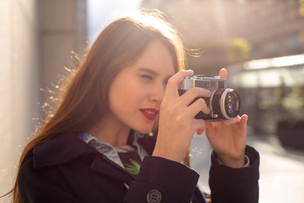Zewnątrz jesień uśmiechający się portret styl życia dość młoda kobieta, zabawy w mieście z aparatu, podróży zdjęcie fotografa. - Zdjęcie, obraz