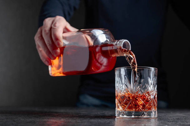 Il barman versa il whisky in un bicchiere al bar. Focus selettivo
. - Foto, immagini