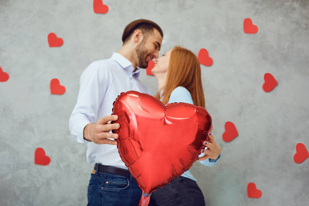 Couple with red heart balloon on a gray background.  - Valokuva, kuva