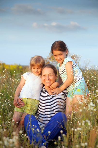 Portrait of   grandmother and two granddaughters of 4 and 6 years old. - Photo, Image
