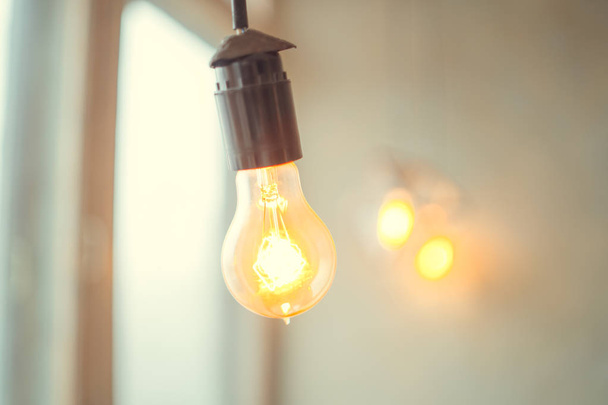 retro vintage light bulb with led technology bult-in on warm light yellow tint and black background energy saving with old style atmosphere concept - 写真・画像