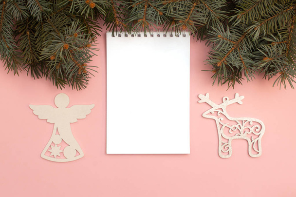 Christmas figures on the pink background with pine tree branches - Photo, Image