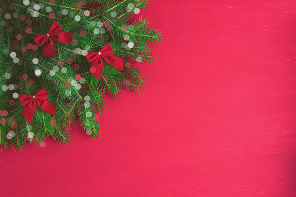 Червоний різдвяний фон з зеленими дерев'яними бантами білий іскровий боке запалює дерев'яний фон. Новорічні веселі різдвяні зимові святкові листівки. Стиль мінімалізму плоский простір перегляду зверху для простору копіювання
. - Фото, зображення