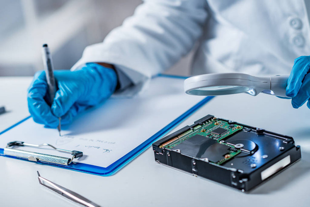Forensic science expert examining hard drive - Photo, Image