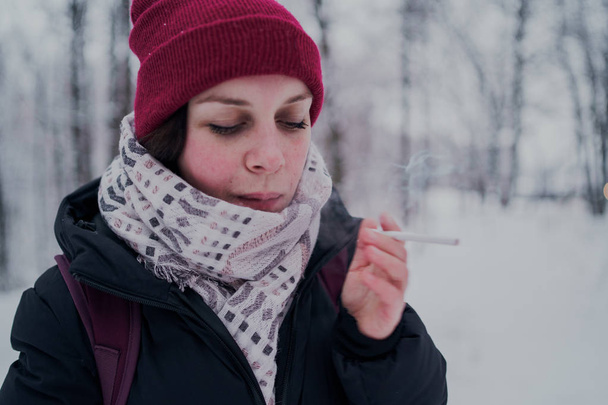 Girl smokes a cigarette. Woman  smokes cigarettes. Tobacco smoke - Zdjęcie, obraz