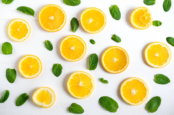 Background with slices of orange and mint leaves. Bright citrus background for banner, website. Pattern with oranges. View from above. Vitamin C. - Foto, Imagem