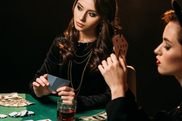 テーブルのカジノでポーカーをプレイする魅力的な女の子 - 写真・画像