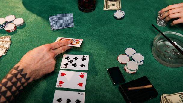 abgeschnittenes Bild von Frau und tätowiertem Mann beim Pokertisch im Casino - Foto, Bild