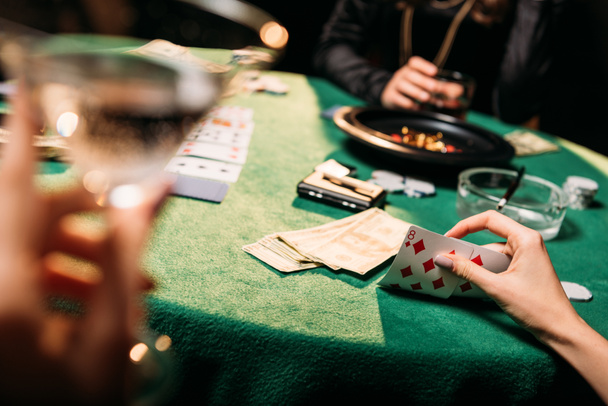 cropped image of women playing poker together at table in casino - Foto, Bild
