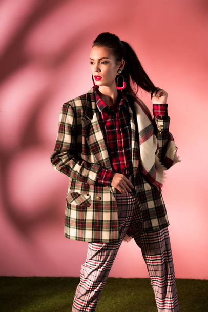 fashionable girl posing in cozy checkered suit on pink background - Fotografie, Obrázek