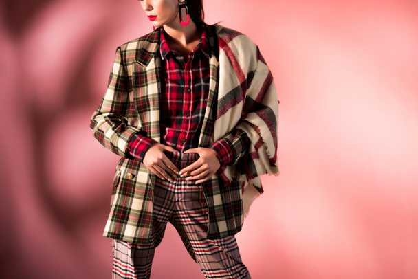 cropped view of girl posing in warm checkered suit on pink background - Photo, image