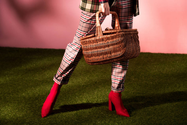 low section view of stylish girl in autumn checkered suit posing with basket - Foto, immagini