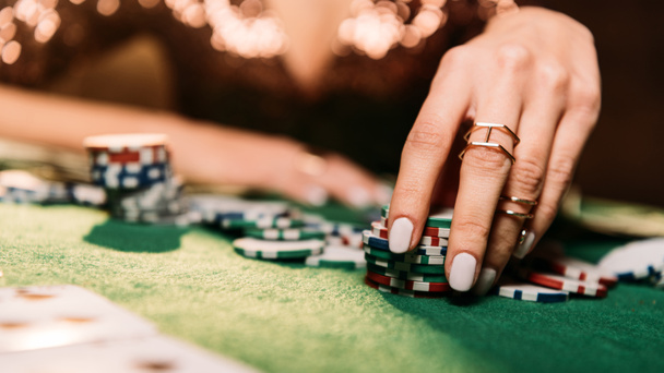 imagen recortada de niña jugando al póquer y tomando fichas en la mesa en el casino
 - Foto, Imagen