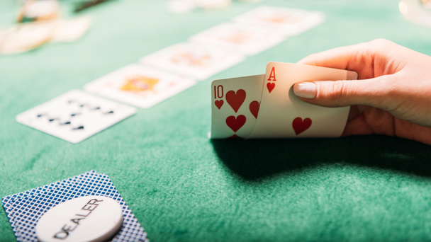 cropped image of girl playing poker and holding cards in casino - Photo, Image