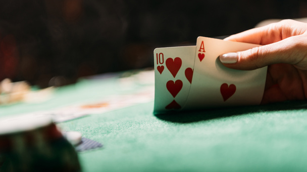 περικομμένη εικόνα γυναίκας παίζει πόκερ και κρατώντας κάρτες καζίνο - Φωτογραφία, εικόνα