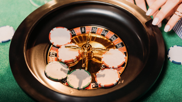 abgeschnittenes Bild von Mädchen, die Roulette im Casino spielen - Foto, Bild