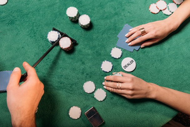 imagen recortada de la mujer y croupier jugando al póquer en la mesa en el casino
 - Foto, imagen