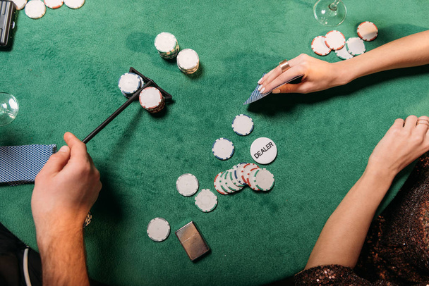 cropped image of girl and croupier playing poker at table in casino - 写真・画像