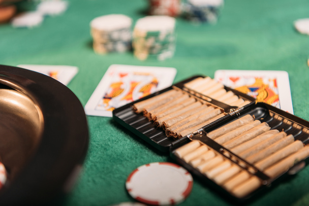 ruleta y cigarros y cartas de póquer en la mesa en el casino
 - Foto, imagen