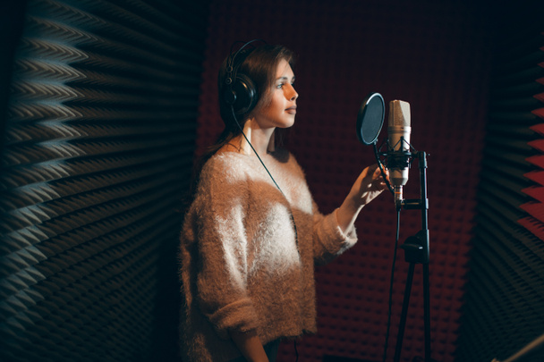 Νέοι σοβαρό ελκυστική γυναίκα που τραγουδά σε ένα στούντιο ηχογραφήσεων - Φωτογραφία, εικόνα