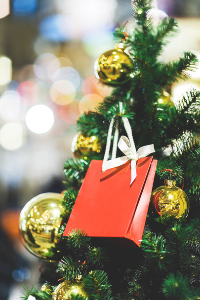 Bild der Weihnachtstanne mit Goldkugeln, rotes Geschenkpäckchen . - Foto, Bild