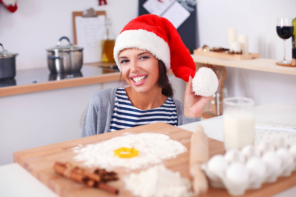 Woman making christmas cookies in the kitchen - Fotoğraf, Görsel