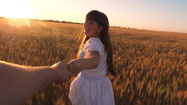 Naurava tyttö juoksee pellon poikki vehnä kädestä pitäen kultaisessa auringossa. Hidastus
. - Materiaali, video