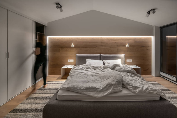 Stylish bedroom in modern style with light walls and luminous lamps - Valokuva, kuva