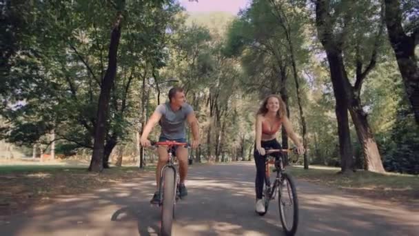 愛するカップルが楽しんで自転車に乗って - 映像、動画