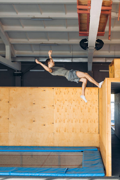 athlete is doing exercise on the air after pushing off the wooden board - 写真・画像