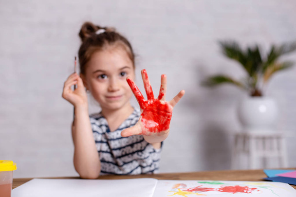 Educazione, scuola, arte e pittura concetto - sorridente studentessa mostrando le mani dipinte a scuola
 - Foto, immagini