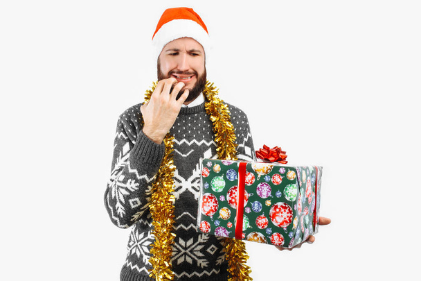 man with a Christmas gift, looking inside, on a white background - Photo, Image