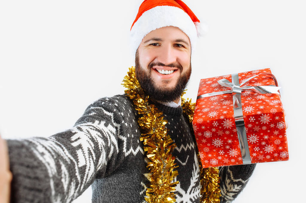 a man takes a picture with a Christmas gift - Фото, изображение