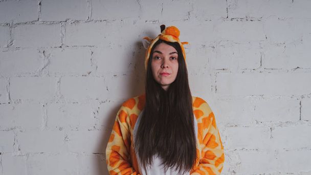 pajamas in the form of a giraffe. emotional portrait of a girl on a gray background. crazy and funny man in a suit. clean skin and long hair. animator for children's parties - Fotó, kép